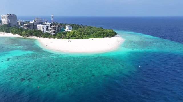 Aerial view of a pristine white sandbar and vibrant turquoise coral reef at Ukulhas island, Maldives.
