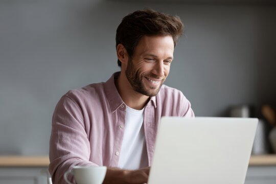 smiling man working on laptop at home comfortable remote work culture concept