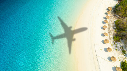 Aerial view of shadow passenger plane silhouette and sandy beach blue sea with waves at sea beach summer vacation sea travel concept	
