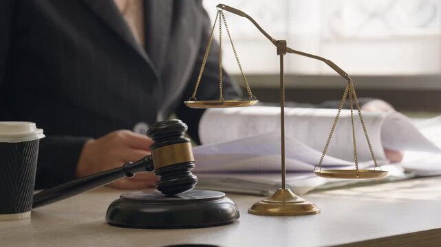 Lawyer working at desk with gavel and scales of justice. Legal consultation, law office and justice system concept in professional legal workplace.