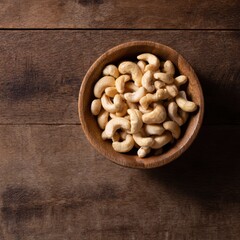 Fototapeta premium Cashew nuts in bowl on wooden table, top view with copy space
