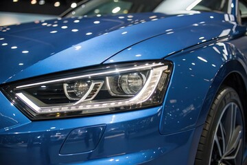 Fototapeta premium Blue car gleams under showroom lights