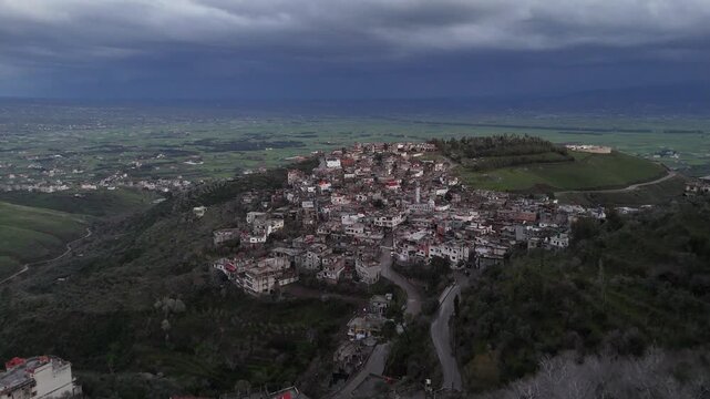 Cinematic high-angle view of the rural landscape of Syria, showcasing agricultural fields and natural beauty under a cloudy sky