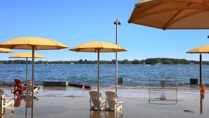 Naklejka premium Yellow umbrellas and plastic chairs on Sugar Beach during flood in Toronto.
