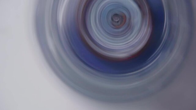 Spinning Top Creating Abstract Circular Patterns with Blue and Red Colors