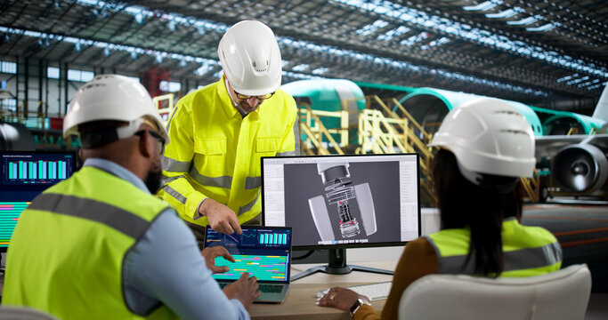 An Engineer And Technician Discuss Jet Engine Repairs Using Laptop Computers
