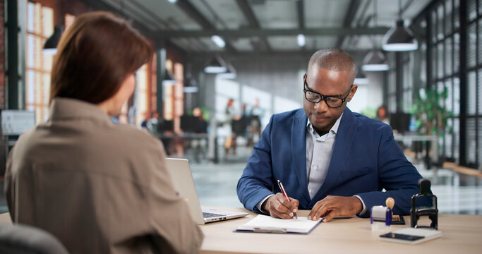 Young Woman And Man Consult Laptop