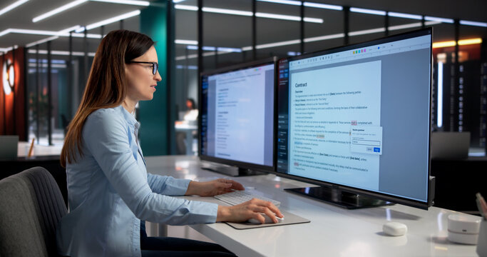 Woman Meticulously Proofreads Document On Computer Monitor