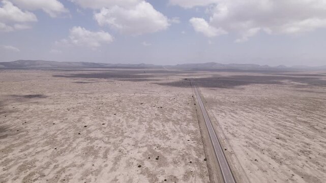 Cloud shadows move across an empty highway in the west Texas desert, aerial view