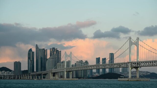 Day to night timelapse of Gwangan Bridge with Busan skyline and dramatic cloud movement