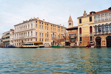 Fototapeta premium View of buildings along the water in Venice during daytime with calm clouds overhead