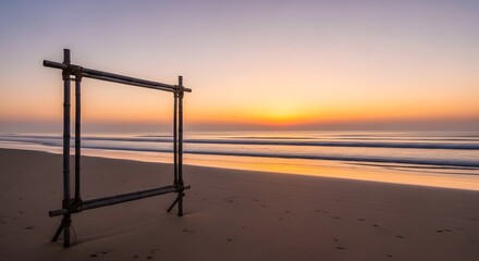 Fototapeta premium Empty wooden frame standing on sandy beach during beautiful sunrise