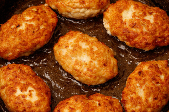 Minced meat cutlets are fried in oil in a frying pan