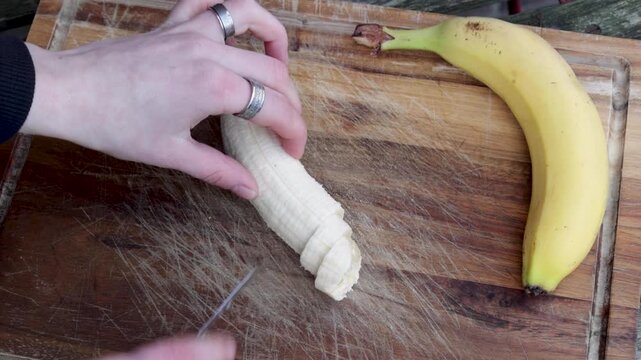 Video of person cutting a banana in even slices.