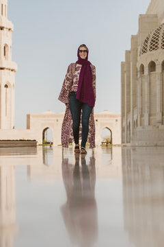 Smiling woman in courtyard of Grand Mosque, Muscat, Oman.