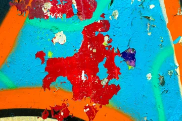 Weathered concrete surface with layers of red blue and orange spray paint. Abstract urban decay texture with distressed paint erosion and gritty street art details for edgy design projects. © Aleksandra Konoplya