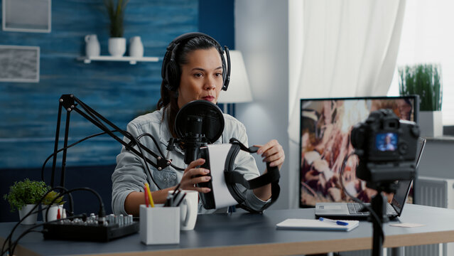 Content creator promoting modern VR headset while recording video. Famous social media influencer doing recommendation video while reviewing high tech weareable goggles to audience.
