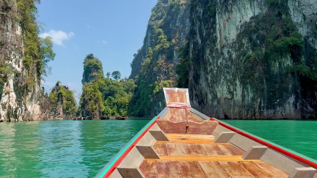 Bow of the boat moving through the beautiful limestone cliffs on the lake in Kao Sok National Park in Thailand