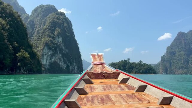 Bow of the boat moving through the beautiful limestone cliffs on the lake in Kao Sok National Park in Thailand