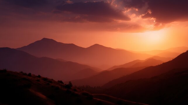 Beautiful landscape of a mountain range during sunrise or sunset. the sky is filled with vibrant orange and pink hues, with the sun partially hidden behind the clouds.
