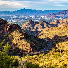 Scenic high angle of road winding through desert mountains to urban area