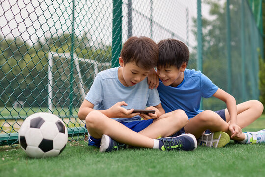 The boys switch from football to a phone game