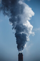 Naklejka premium A haunting view of industrial chimneys spewing black smoke