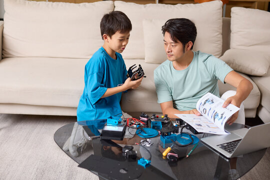 A father and son work together to assemble a toy robot