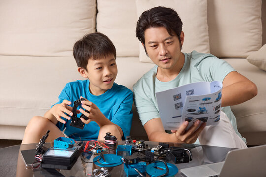A father and son work together to assemble a toy robot