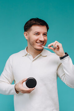 Man holding clear aligner and case, smiling about dental care and orthodontic treatment