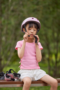 A girl puts on her protective gear for roller skating