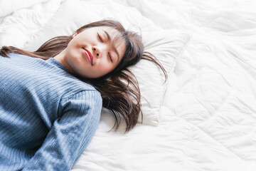 布団に入って睡眠を取る若い女性