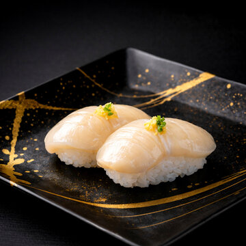 Premium fresh scallop hotate sushi on a luxury black ceramic plate with gold brushstrokes, dramatic lighting, high-end traditional Japanese cuisine.