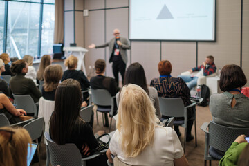 Business presentation with speaker engaging attentive audience in modern conference room, networking, learning, collaboration. © Anton Gvozdikov