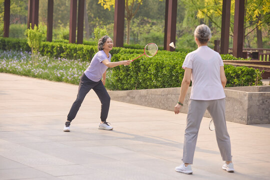 Senior women playing badminton in a park