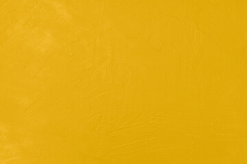 Naklejka premium Yellow painted wall with abstract textured surface and brush marks. Ideal background for design, branding, and vibrant concepts.