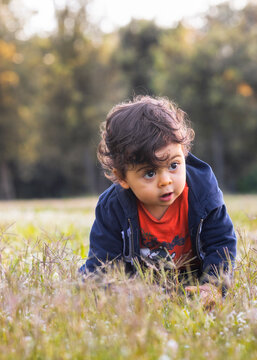neonato moro gioca felice sul prato fiorito di margherite in una bella giornata primaverile