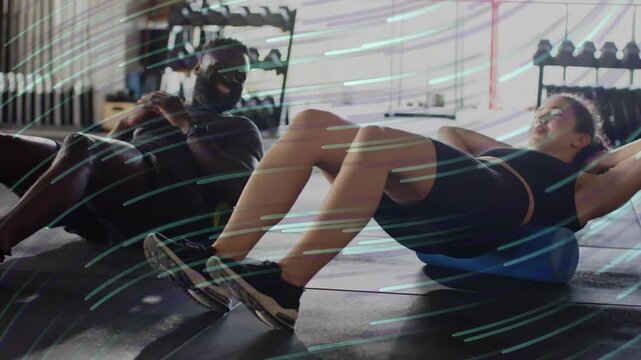 Woman starting foam roller crunches, man adjusting ball, animated streaks showing fitness mobility