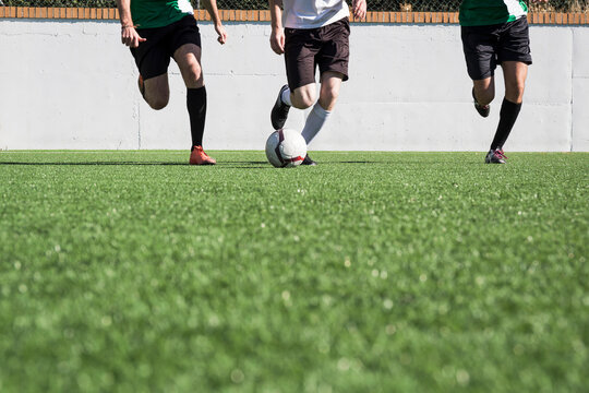 Legs of football players during a match on the field