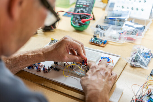 Senior man working on electronic circuits in his workshop