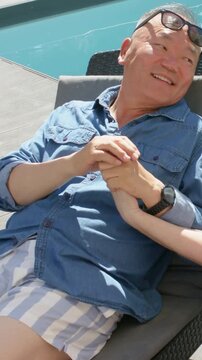 Vertical video: Reaching partner's hand, man holding hand by pool, showing affection, watch visible