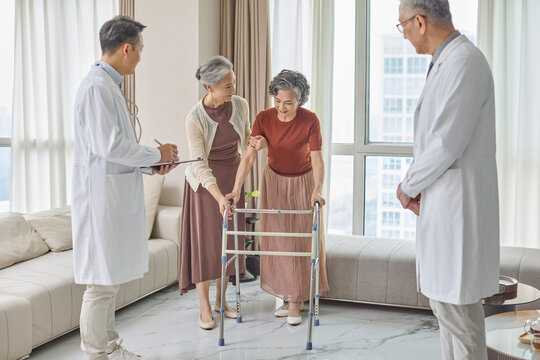 Senior woman using a walking frame under her doctor's supervision
