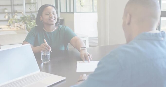 Bands clearing, woman green writing, sliding paper, man blue shirt reaching to review at office