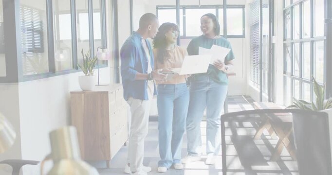 Man left, woman center, woman right opening large plans, scanning and discussing for design review
