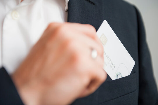 Businessman removing credit card from suit pocket