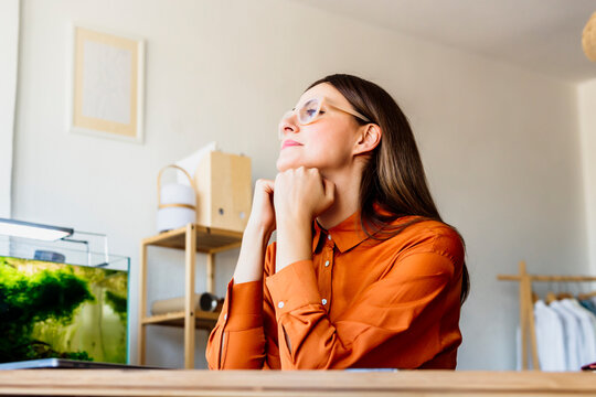 Female fashion designer at home sitting at desk having a break