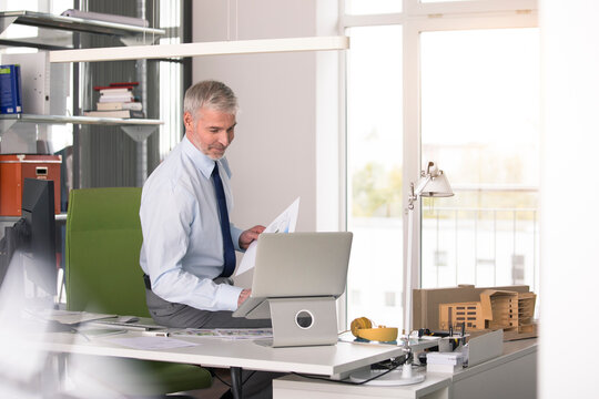 Businessman working in office, using laptop
