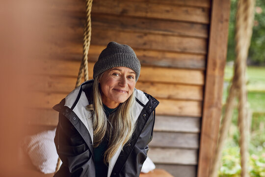 Smiling mature woman wearing knit hat in back yard