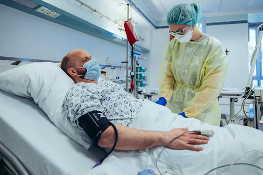 Doctor caring for patient in emergency care unit of a hospital taking blood sample
