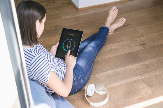 Young woman with tablet awith smart home control functions and headphones